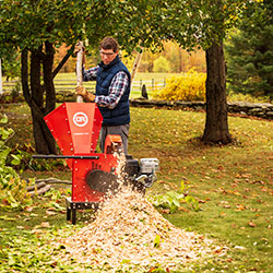 Man putting branches in a chipper