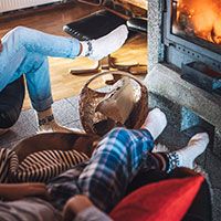 People in front of cozy fire in living room